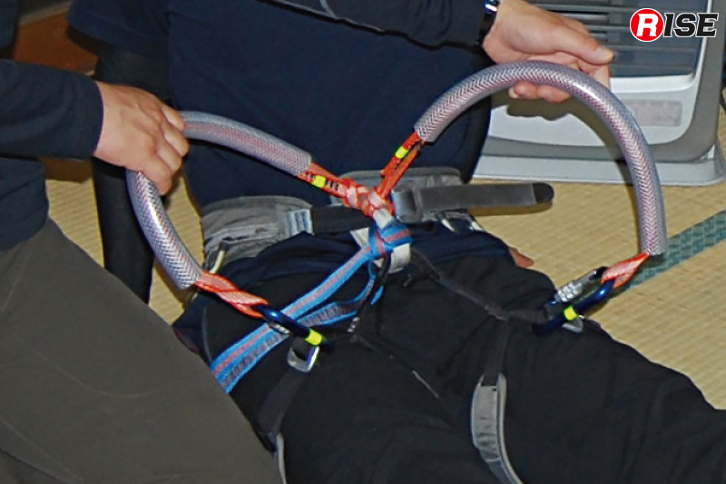 要救助者を背負って搬送するための工夫。オリジナルアイテムを作りハーネスなどを背負子として使用できるようにしている。