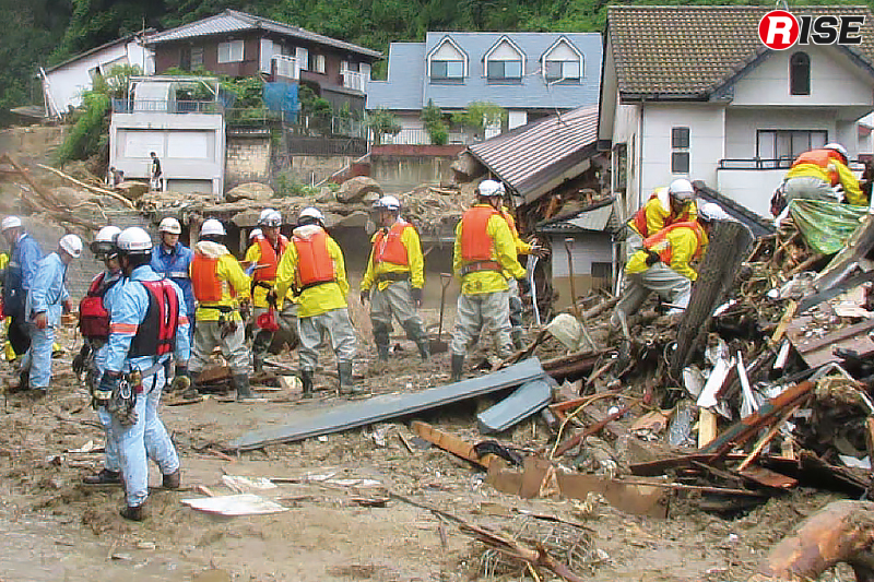 倒壊した住宅の内部検索を図るべく瓦礫などを丁寧に取り除き、一列に並びリレー方式で搬出する隊員ら。