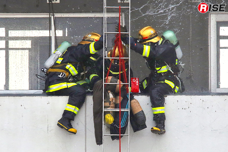 歩行不能の要救助者を応急はしごにより救出する。
