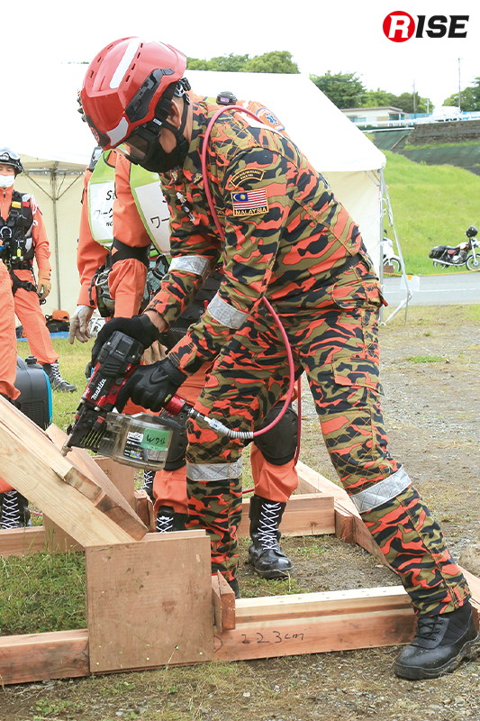 釘打機のレクチャーを受けるマレーシアの隊員。