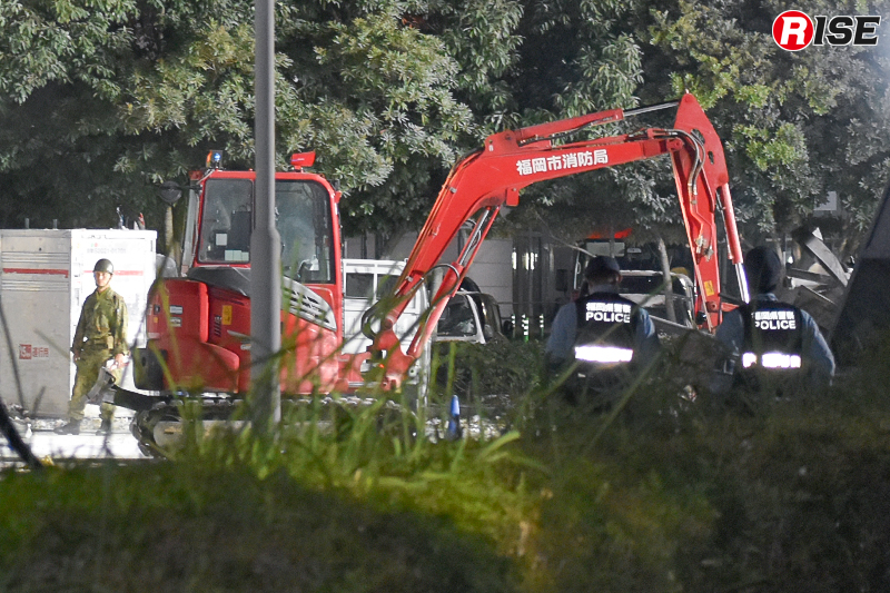 現場には福岡市消防局と佐賀広域消防局の重機が投入されていた。消防重機で建物内の瓦礫を引き出し、自衛隊の大型重機が搬出を担うなど、それぞれの特性を生かした連携が図られていた。